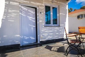 A white building with a closed door, a window, and a bench outside. - Futura Club Acqua Di Venere (Capaccio-Paestum)