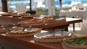 A buffet table with various dishes, outdoor seating, and a pool in the background. - Futura Club Acqua Di Venere (Capaccio-Paestum)