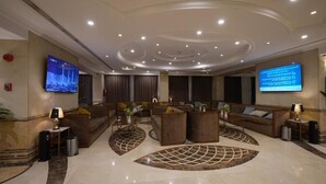 A spacious lobby with a modern design, featuring sofas, a coffee table, and a large screen. - Astoneast Taiba Hotel Ex Artal Al Alami  (Madinah)