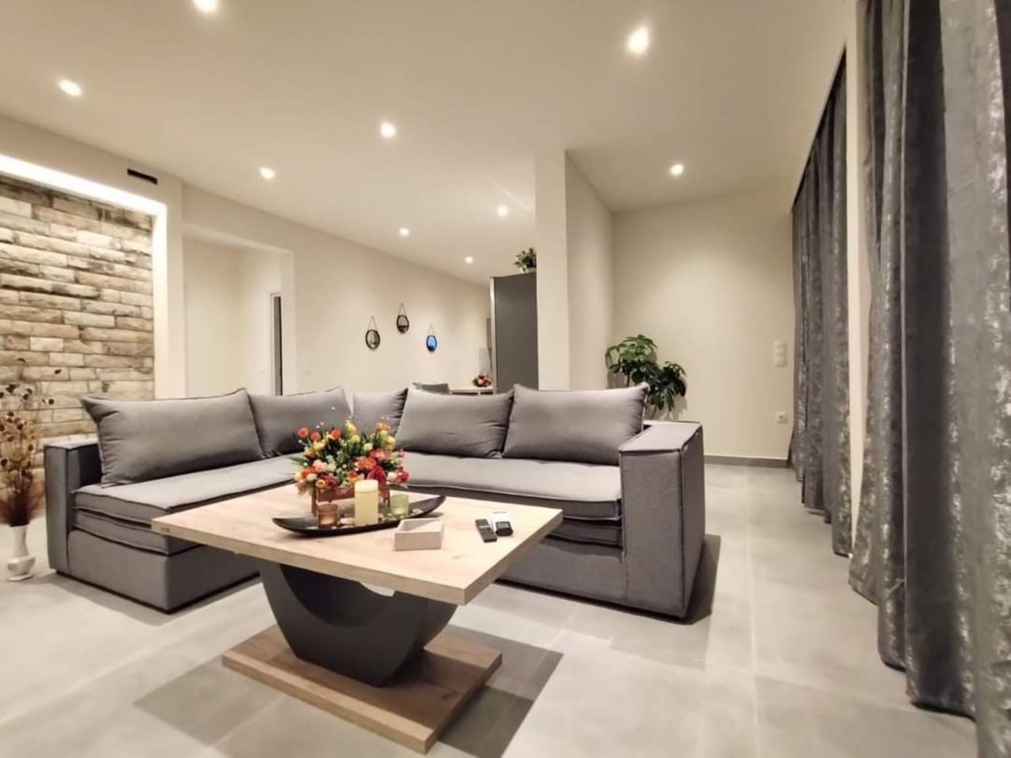A modern living room with a sectional sofa, a coffee table, and a decorative vase.