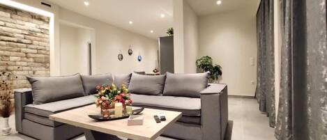 A modern living room with a sectional sofa, a coffee table, and a decorative vase.