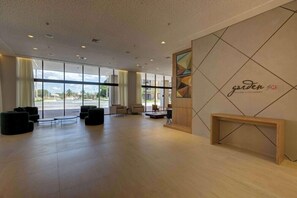 A spacious lobby with large windows, a modern seating area, and a wall with a geometric design and text. - Hilton Garden Inn Sao Jose do Rio Preto (São José do Rio Preto)