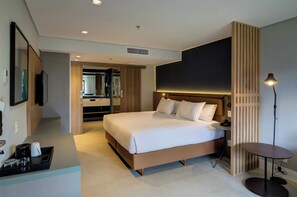 A modern hotel room with a large bed, bedside table, and a small round table with a lamp. - Hilton Garden Inn Sao Jose do Rio Preto (São José do Rio Preto)
