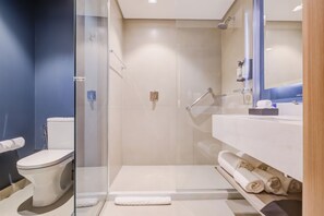A modern bathroom with a glass-enclosed shower, a white toilet, and a vanity with towels. - Hilton Garden Inn Sao Jose do Rio Preto (São José do Rio Preto)