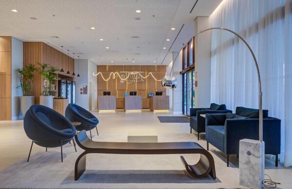 A modern lobby with a reception desk, seating area, and a large floor lamp. - Hilton Garden Inn Sao Jose do Rio Preto (São José do Rio Preto)
