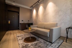 Un salon moderne avec un canapé, une table basse et un mur orné d’un motif.