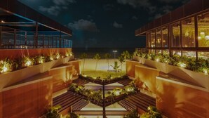 A modern hotel with a central courtyard, glass railings, and plants. - Bara Hotel Joao Pessoa (João Pessoa)