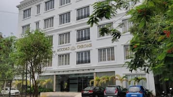 A multi-story building with the name 'Accord Chrome' on the facade. There are several cars parked in front, and the building has multiple windows.