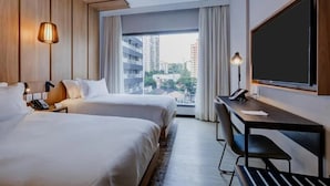 A hotel room with two beds, a desk, a chair, a TV, and a window with a city view. - Radisson Hotel Pinheiros, Sao Paulo (São Paulo)