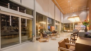 A modern interior with a reception desk, seating area, and large windows. - Radisson Hotel Pinheiros, Sao Paulo (São Paulo)