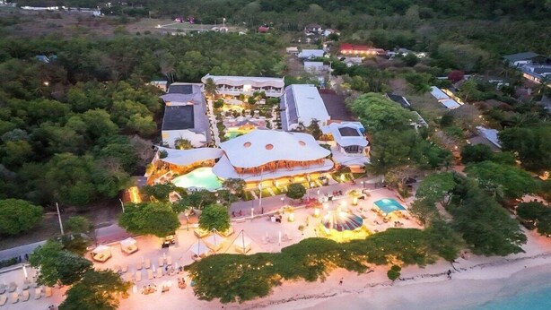 An aerial view of a resort with a central building, multiple pools, and a beach area. - Pearl Sunset Resort (Gili Trawangan)