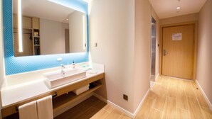 Ein modernes Badezimmer mit einem großen Spiegel, zwei Waschbecken und einer Holzausstattung.