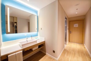 Un baño moderno con un espejo grande, dos lavamanos y un mueble de tocador de madera.