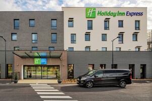 Un edificio de Holiday Inn Express con un diseño moderno, que presenta una fachada plana y una entrada amplia.