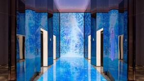 A modern elevator with a reflective floor and walls, featuring a central transparent section. - W Xiamen (Xiamen)