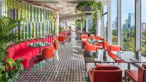 A modern restaurant with red seating, large windows, and a patterned floor. - W Xiamen (Xiamen)