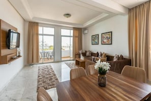 Una sala de estar moderna con comedor, ventanas amplias y balcón.