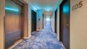 A hotel hallway with a carpeted floor, doors on both sides, and a number '505' on the right wall. - Nyce Hotel Ulm (Ulm)