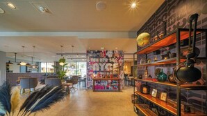 Ein modernes Interieur mit einer zentralen Wand, verziert mit verschiedenen Postern, und einem Holzregal mit Dekorationselementen.