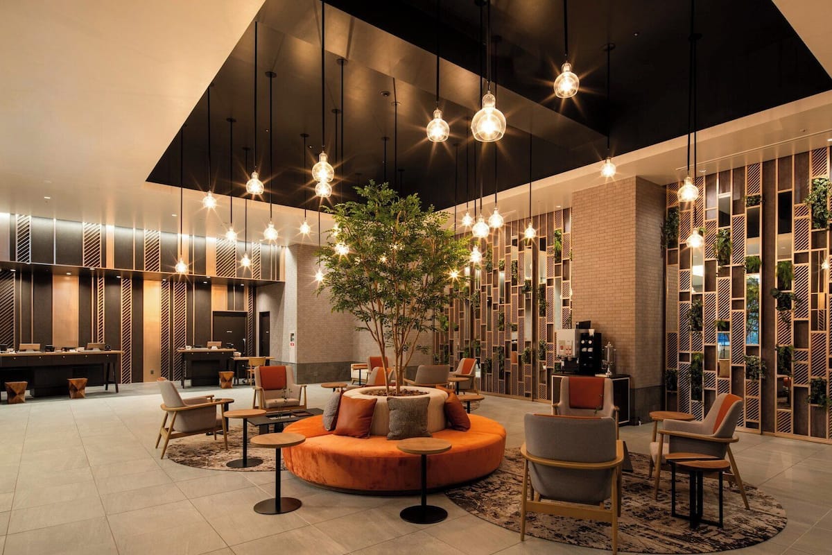 A modern lobby with a central seating area, a reception desk, and a wall with vertical gardens.
