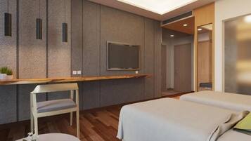 A modern hotel room with a bed, a desk with a chair, a television, and a shower area.