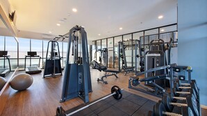 A modern gym with cardio machines, weightlifting equipment, and exercise balls. - Harper Kupang (Kupang)