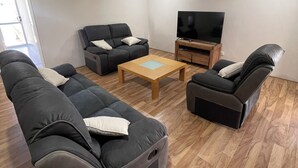 A modern living room with a sofa set, a coffee table, and a television. - Rehoboth Landsdale WA (Landsdale)