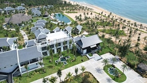 Un resort con varias edificaciones, piscina y playa.