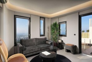 Ein modernes Wohnzimmer mit einem grauen Sofa, einem runden Couchtisch und einer Topfpflanze.