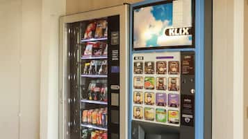 A vending machine with a variety of snacks and drinks, and a digital display screen.
