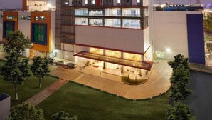 A multi-story hotel with a modern design, featuring a prominent rooftop sign and a well-lit entrance. - H! Hotel Senen (Jakarta)