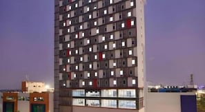 A high-rise building with multiple floors, each with a balcony. - H! Hotel Senen (Jakarta)