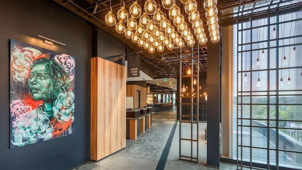 A modern interior with a long corridor, wooden partitions, and hanging light fixtures. - Sage Ringwood (Melbourne)