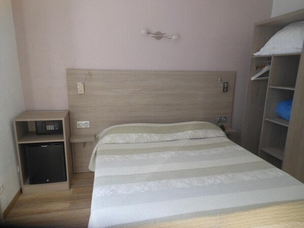 Ein Schlafzimmer mit einem Bett, einem Nachttisch, einer Kommode und einem Kleiderschrank.