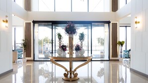 A spacious lobby with a central decorative table, large windows, and modern lighting fixtures. - Dream Residence Olaya Khobar (Al Khobar)
