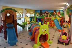 Un espace de jeux pour enfants avec différentes structures, notamment un toboggan et un tunnel.