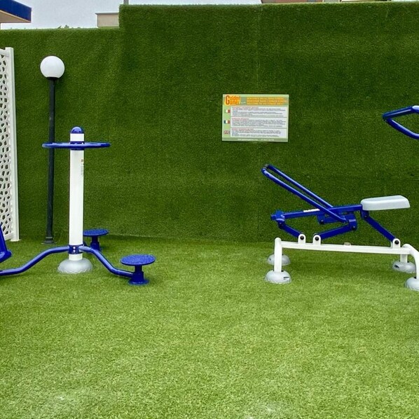 Buitenfitnessapparatuur op kunstgras.