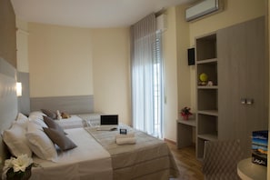 Une chambre d’hôtel avec deux lits, un bureau, une chaise, une télévision et une armoire.