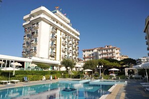 A hotel with a swimming pool, multiple balconies, and a clear sky. - Hotel Beny (Jesolo)
