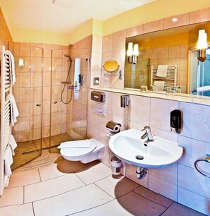 Un baño moderno con ducha envuelta en vidrio, inodoro y lavamanos.