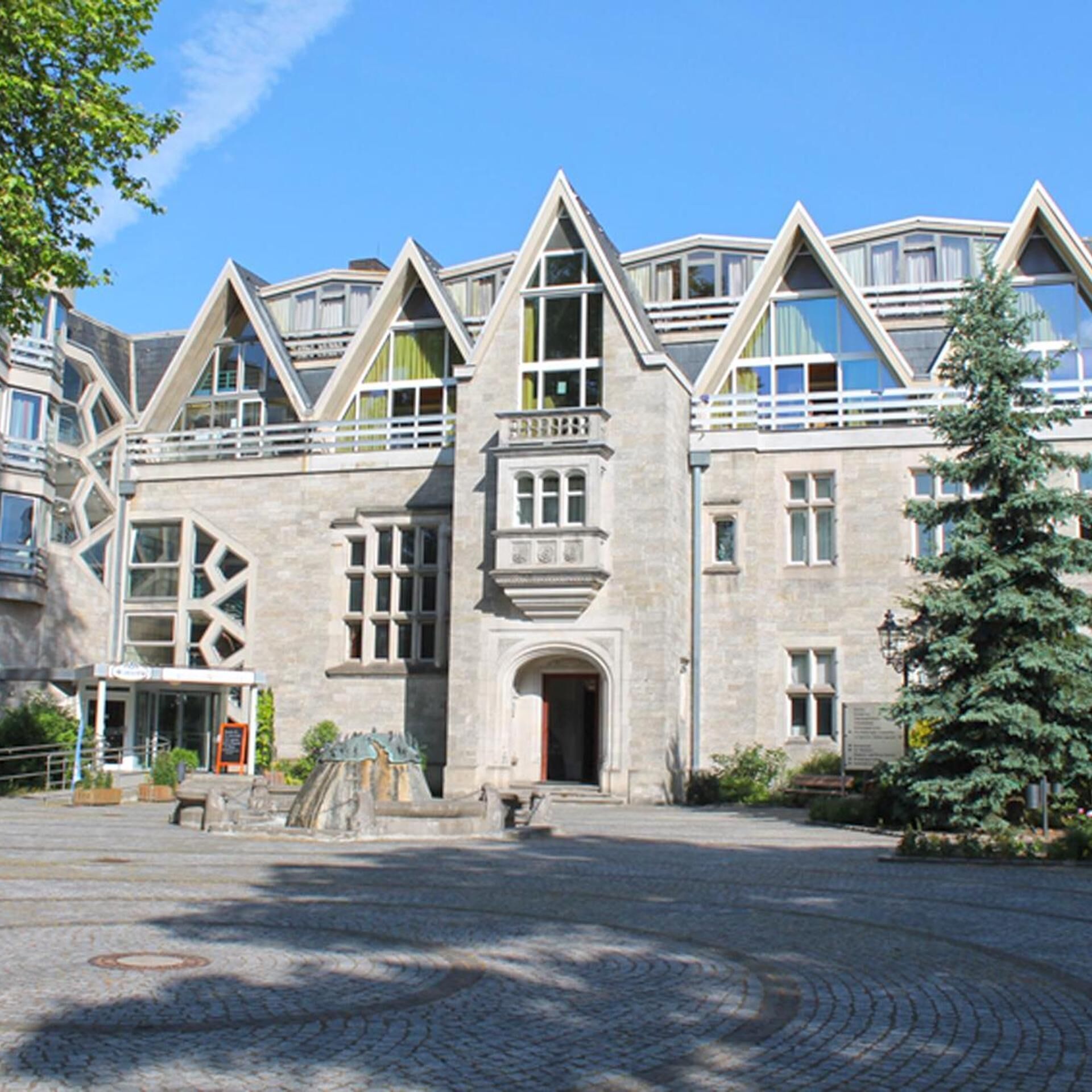 A large stone building with a symmetrical facade, multiple windows, and a central entrance.