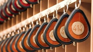 A row of numbered keycards hanging on a metal rack. - Hotel Ludwig Superior (Cologne)