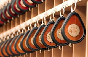 A row of numbered keycards hanging on a metal rack. - Hotel Ludwig Superior (Cologne)