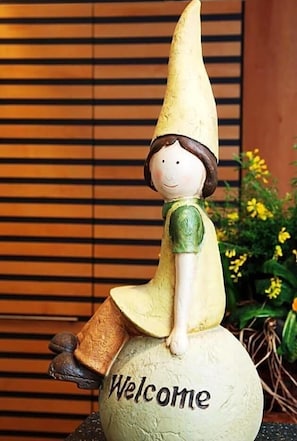 A figurine of a person sitting on a globe with the word 'Welcome' on it. - Hotel Ludwig Superior (Cologne)