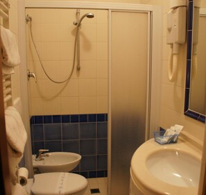 Une salle de bain équipée d’une douche, de toilettes, d’un lavabo et d’un porte-serviettes.