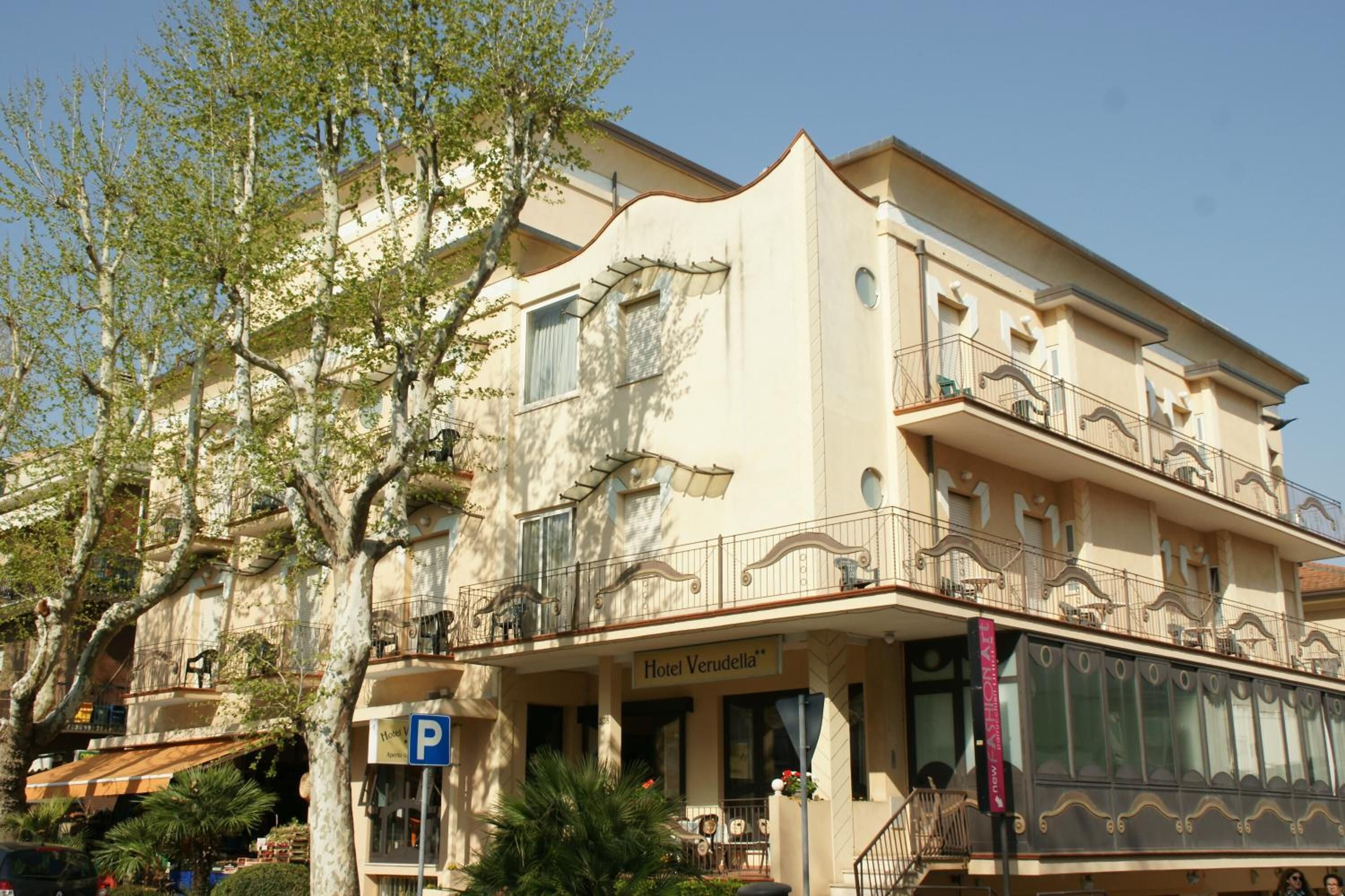 A hotel with a balcony, a sign reading "Hotel Verudella," and a parking sign.