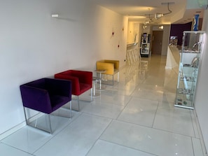 A modern lobby with a reception desk, a vending machine, and a glass display case. - La Suite Hotel (Vigo)