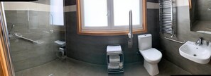 A modern bathroom with a glass shower enclosure, a toilet, a sink, and a towel rack. - La Suite Hotel (Vigo)
