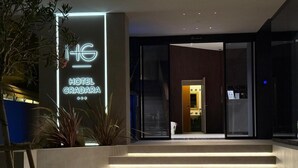 A modern hotel entrance with a neon sign, a staircase, and a glass door leading inside. - Hotel Gradara (Bellaria-Igea Marina)