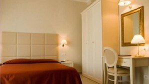 A hotel room with a bed, a desk, a chair, a wardrobe, and a mirror. - Hotel Gradara (Bellaria-Igea Marina)